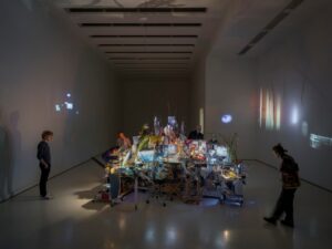 A group of people standing in a room with a large table AI-generated content may be incorrect.